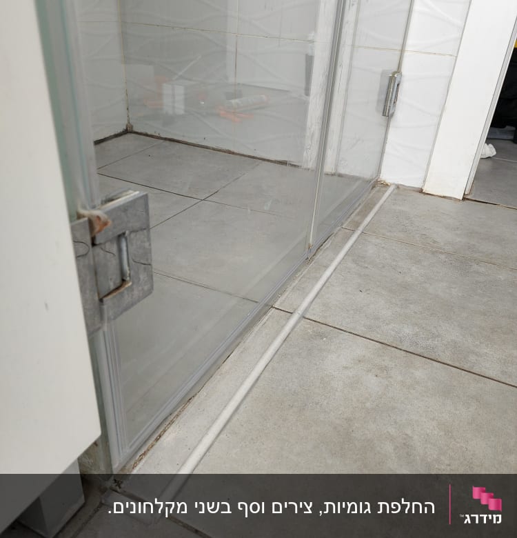 מקלחון זכוכית עם רצפת אריחים אפורים